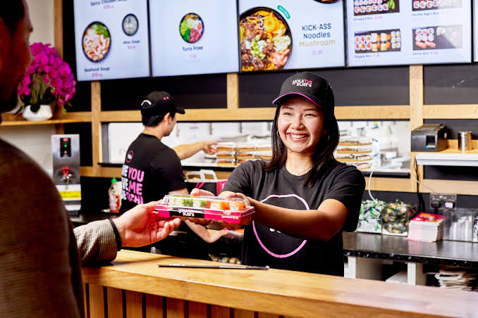 YouMeSushi team serving customers at the counter